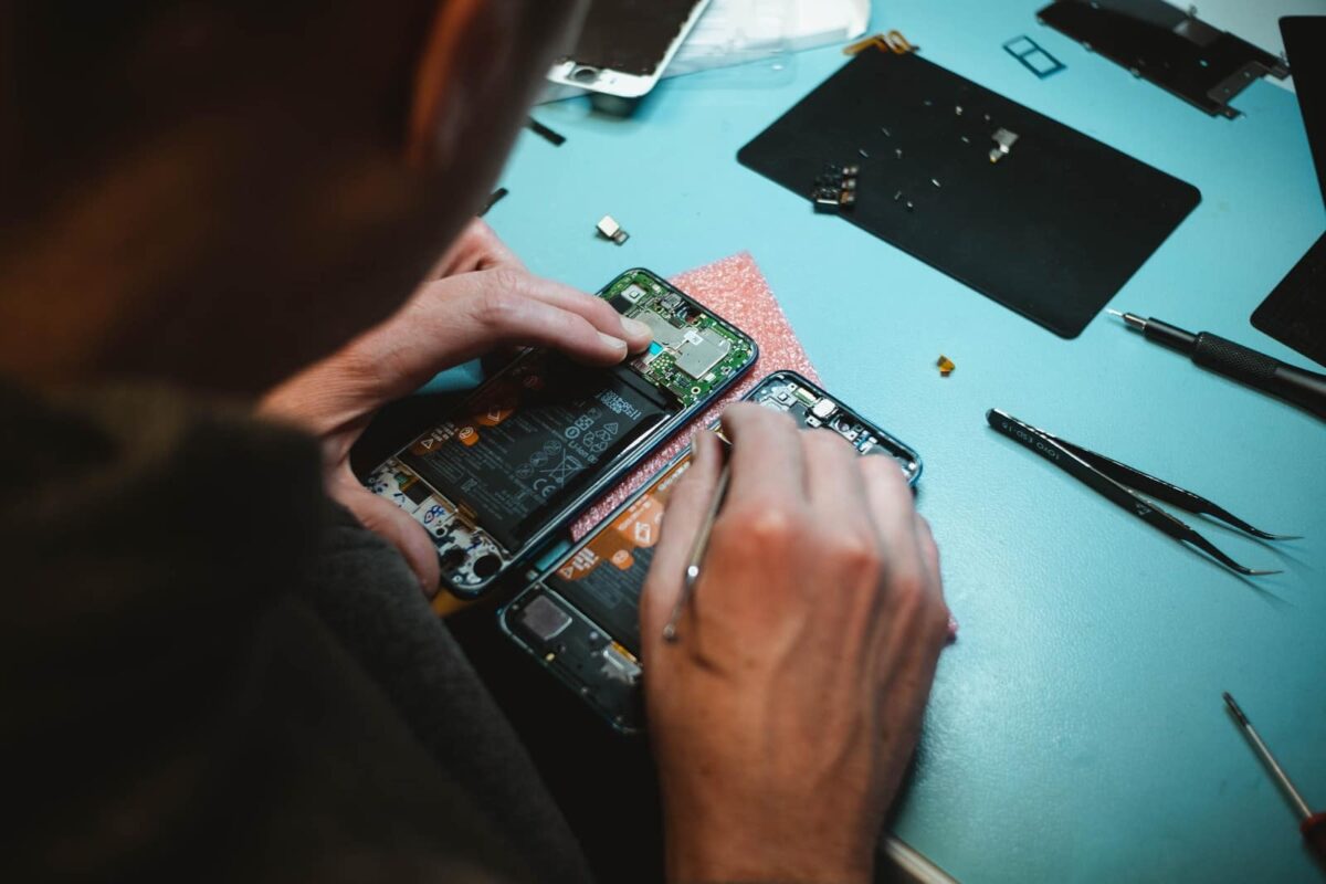 circular economy Photo by Kilian Seiler person repairing smartphones under a lighted table
