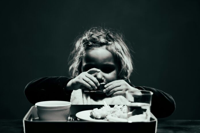a woman sitting at a table with a tray of food